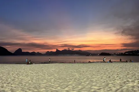 Sonnenuntergang über dem Strand von Icaraí mit den Bergen von Rio am Horizont