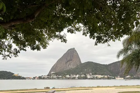 Der Zuckerhut auf der anderen Seite des Wassers, von Flamengo aus zwischen Bäumen hindurch gesehen