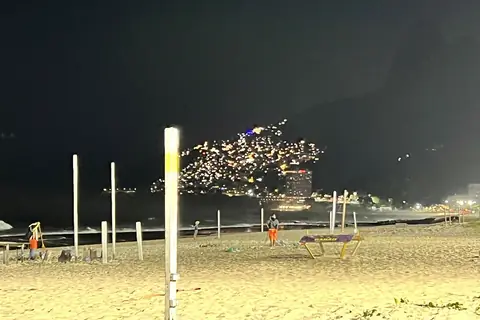 Strand von Ipanema bei Nacht mit Lichtern am Hang des Morro Dois Irmãos