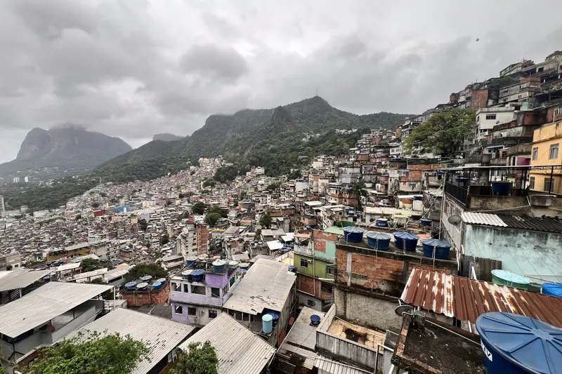 La Rocinha à flanc de montagne, avec des nuages et des crêtes en arrière-plan